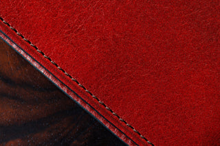 Close-up of a red leather surface with stitching detail